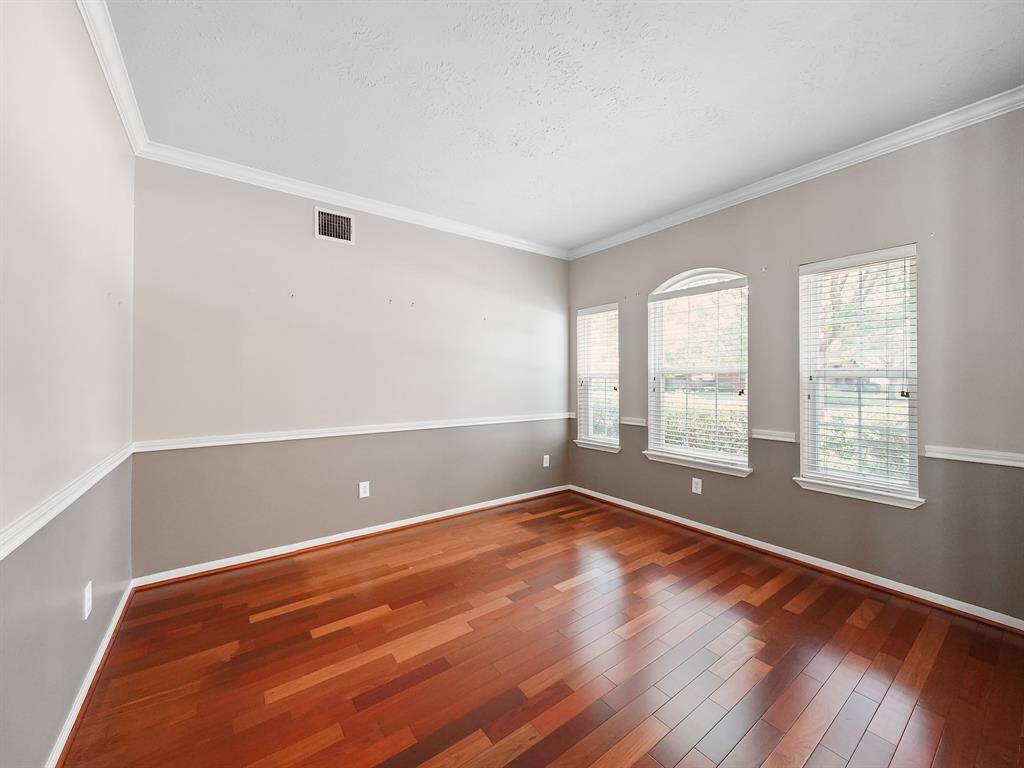 Formal dining room complete with chair rail and crown molding, plus views of the front yard.