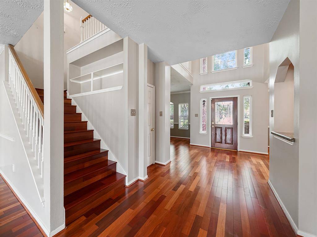Beautiful wood staircase ushers you upstairs.  Built-in shelving for books or a space for sentimental items. Wood spindles and banister compliment the wood stairs and floor.