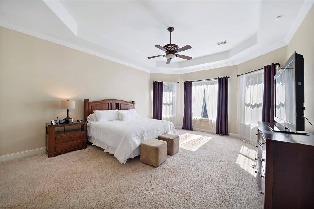 Large master bedroom with lots of windows and natural light as well as coffered ceilings