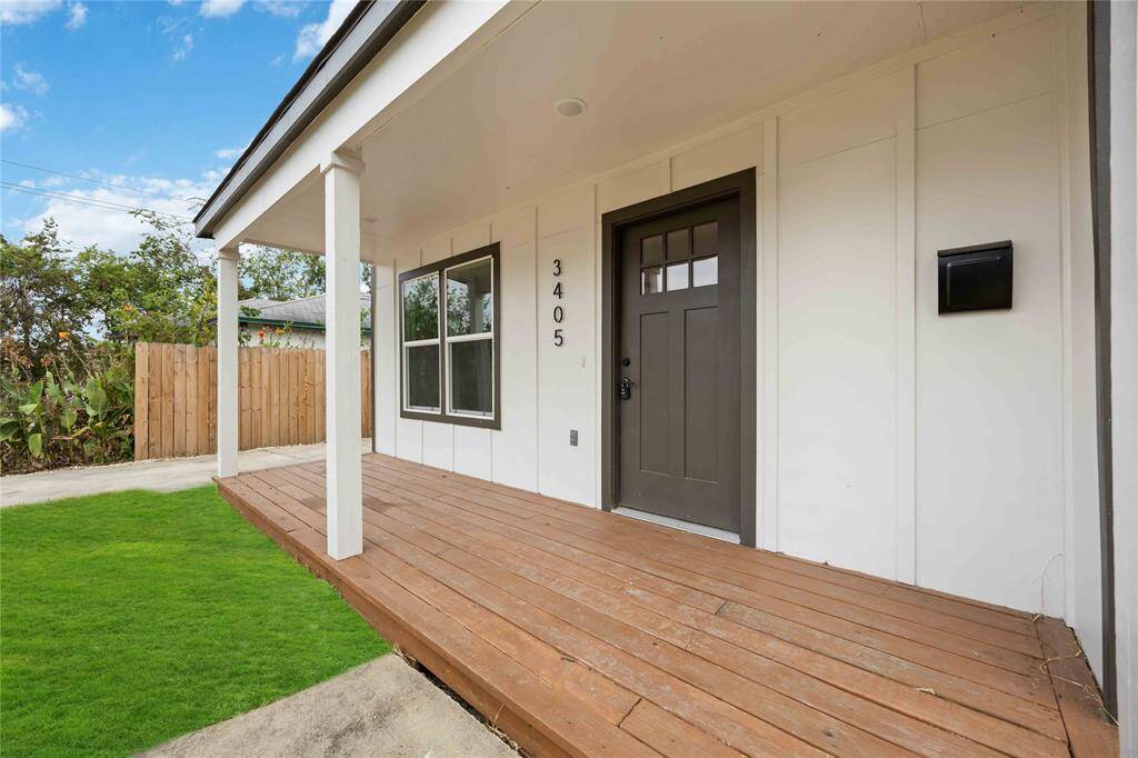 The front entry of the modern home with an extended wooden porch, plenty of space for personalization.