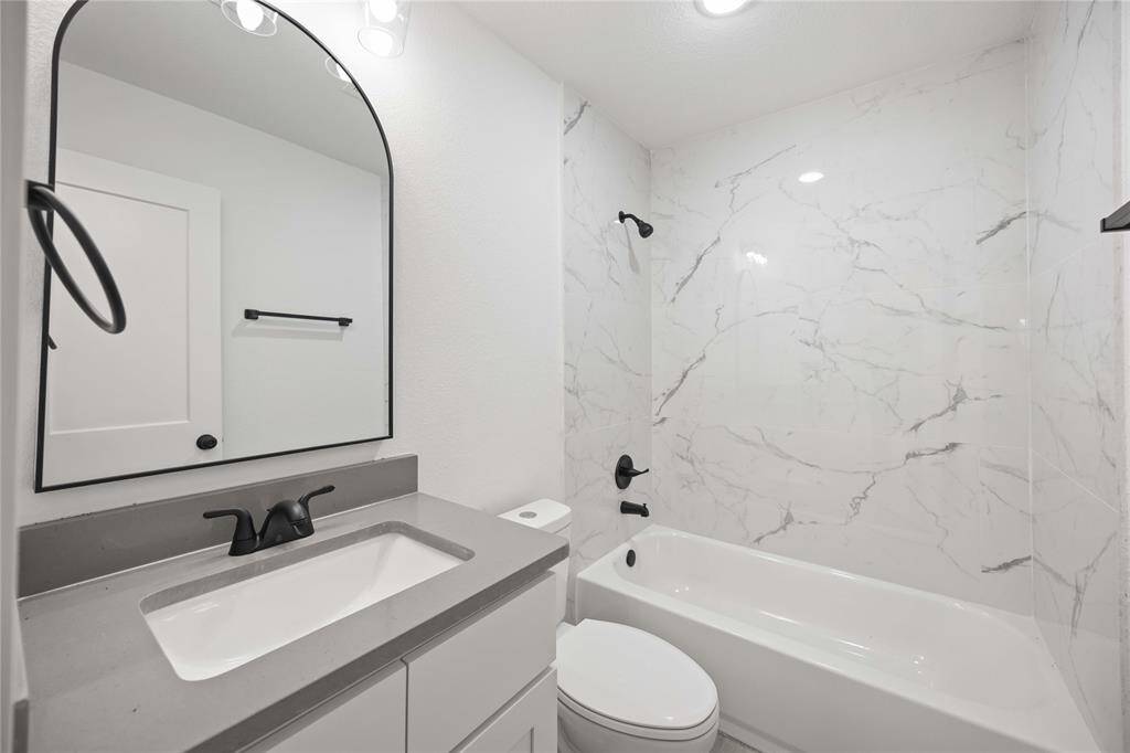 Elegant bathroom with modern fixtures and marble-inspired tiles.