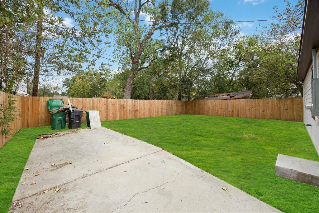 There's a concrete patio area suitable for outdoor seating or activities and the space is versatile for landscaping or garden potential.