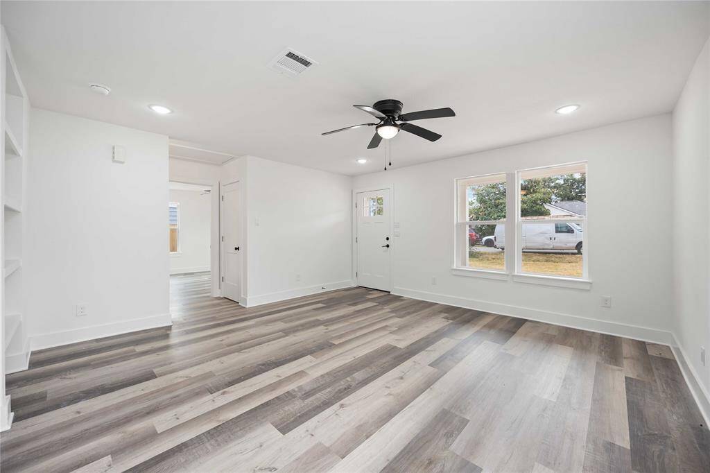 Discover seamless living in this bright space, showing off expansive windows and a welcoming entryway. To the left is the built-in shelving for smart storage solutions.