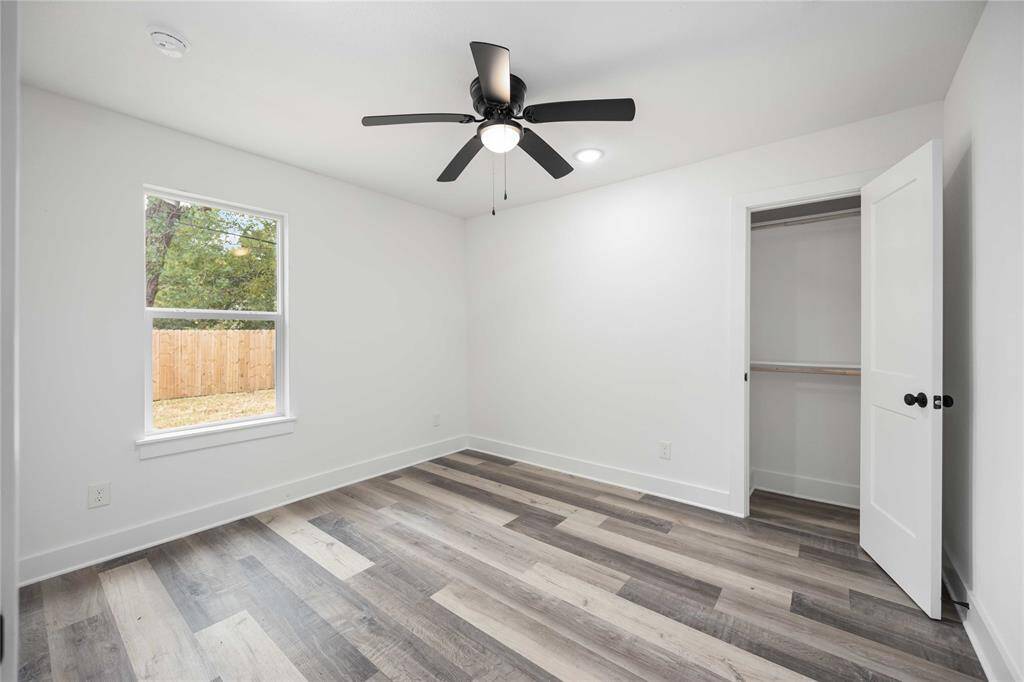 Charming third bedroom featuring ample closet space and a modern ceiling fan.