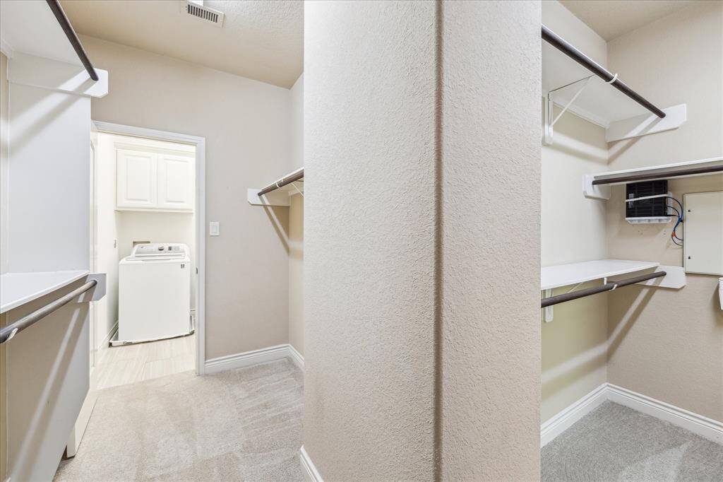 Expansive walk-in closet with built-ins and direct laundry access—designed for daily ease and organization.