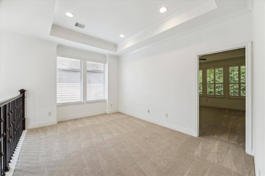 Bright upstairs den features a tray ceiling, recessed lighting, and large windows that fill the space with natural light—perfect for a media room, office, or reading nook.