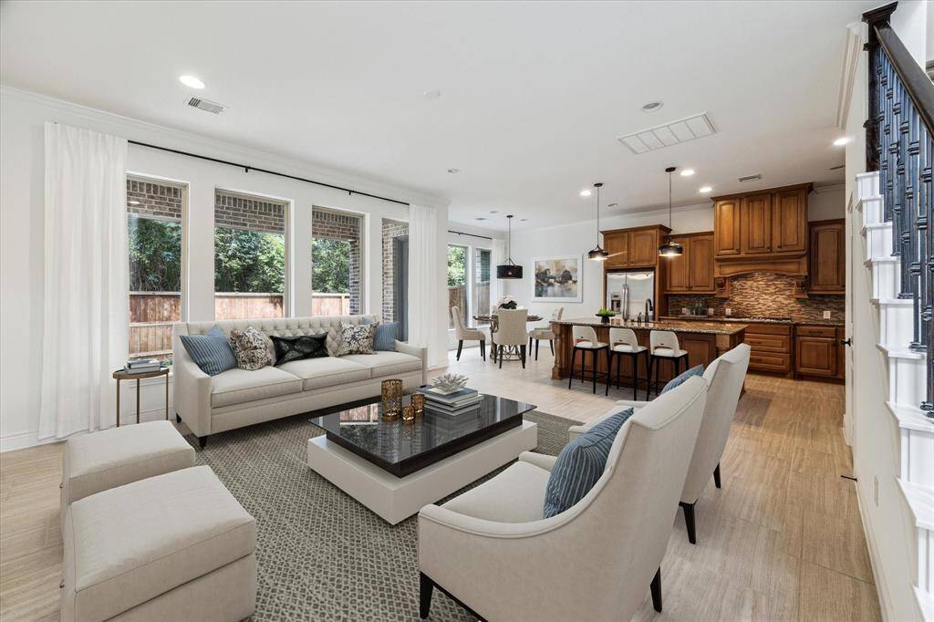 Virtual stage photo of the living room with views of the kitchen and breakfast room.