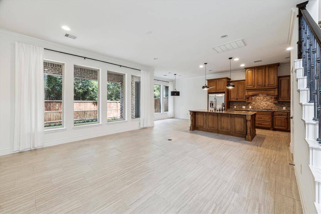 Spacious and bright, this open-concept living area boasts soaring ceilings with recessed lighting, and a stylish kitchen—perfect for modern living and entertaining.