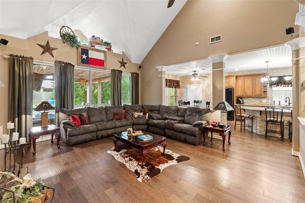 View of spacious living room showing how it opens seamlessly to a kitchen with a breakfast bar, creating an inviting and open-concept space perfect for entertaining.