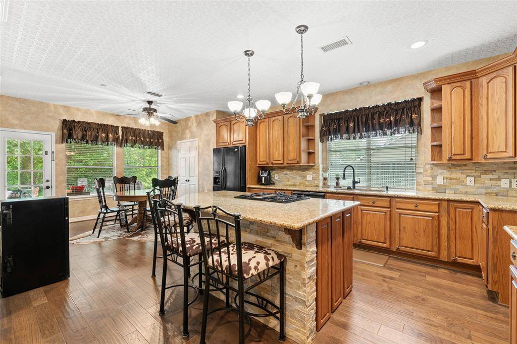 A large central island with seating, and granite countertops make a great area for gathering around the cook.