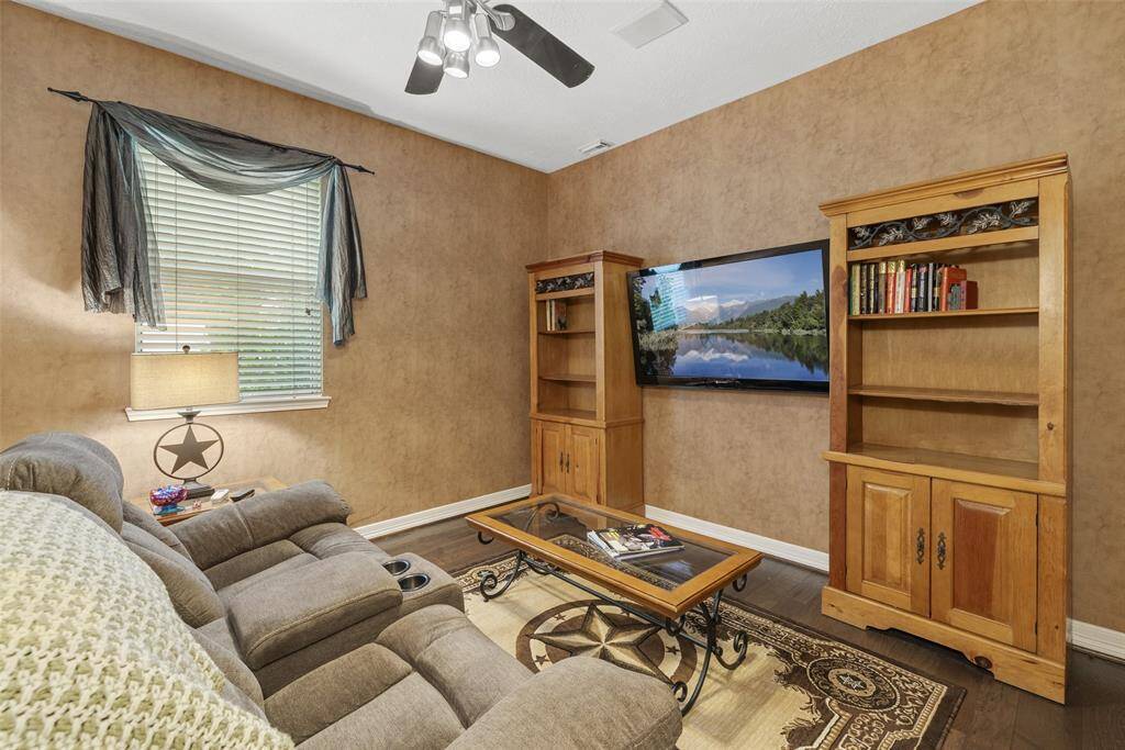 Cozy sitting room with warm, earth-toned walls and wood flooring adjoin primary bedroom. Perfect hideaway for relaxation.