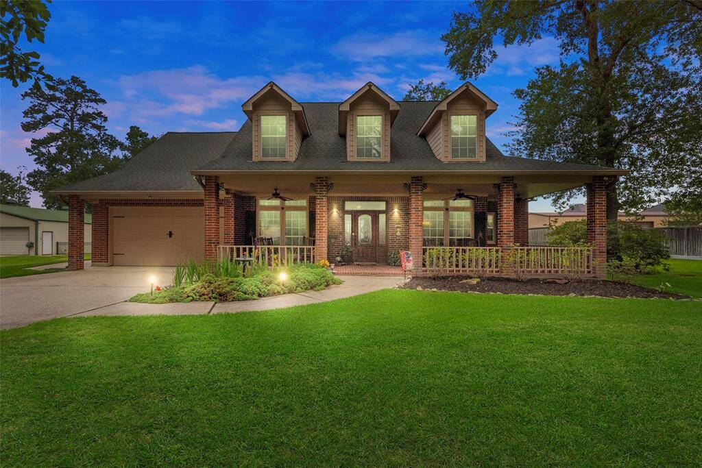 This two-story brick home with a welcoming front porch and dormer windows. The spacious yard is well-maintained, featuring a manicured lawn and mature trees, creating a serene and inviting atmosphere.