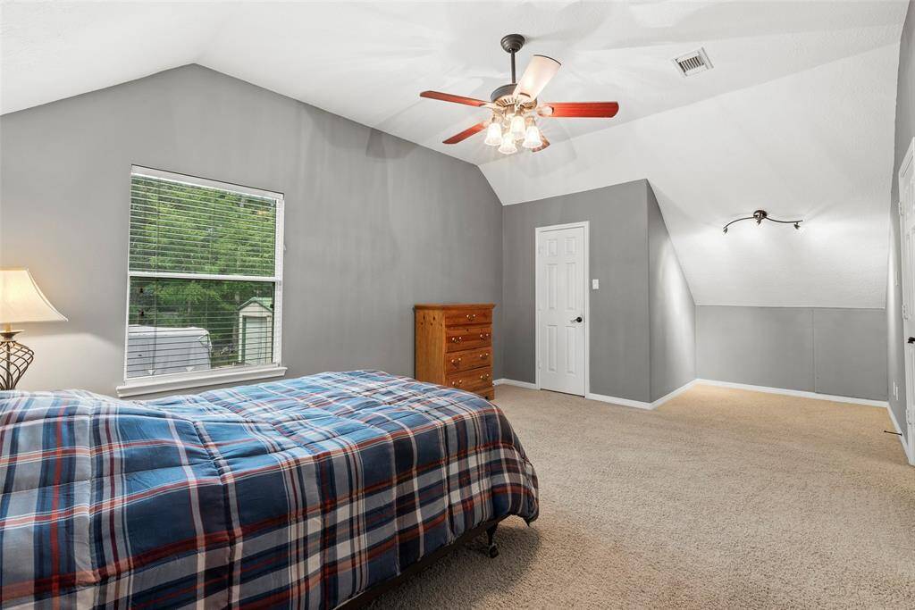 Slanted ceilings add uniqueness to room with walk in closet and nice window for natural light.