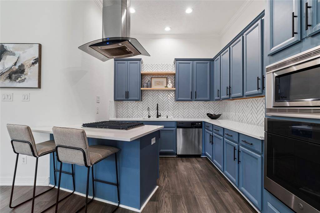 Clean cabinetry, stainless accents, and quartz counters create a modern yet warm kitchen aesthetic.