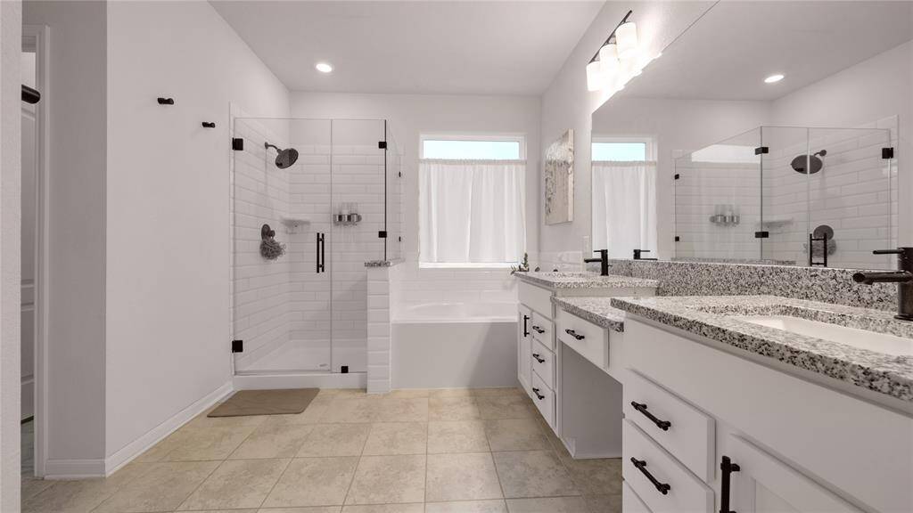 Spacious primary bathroom with frameless shower surround and soaking tub.