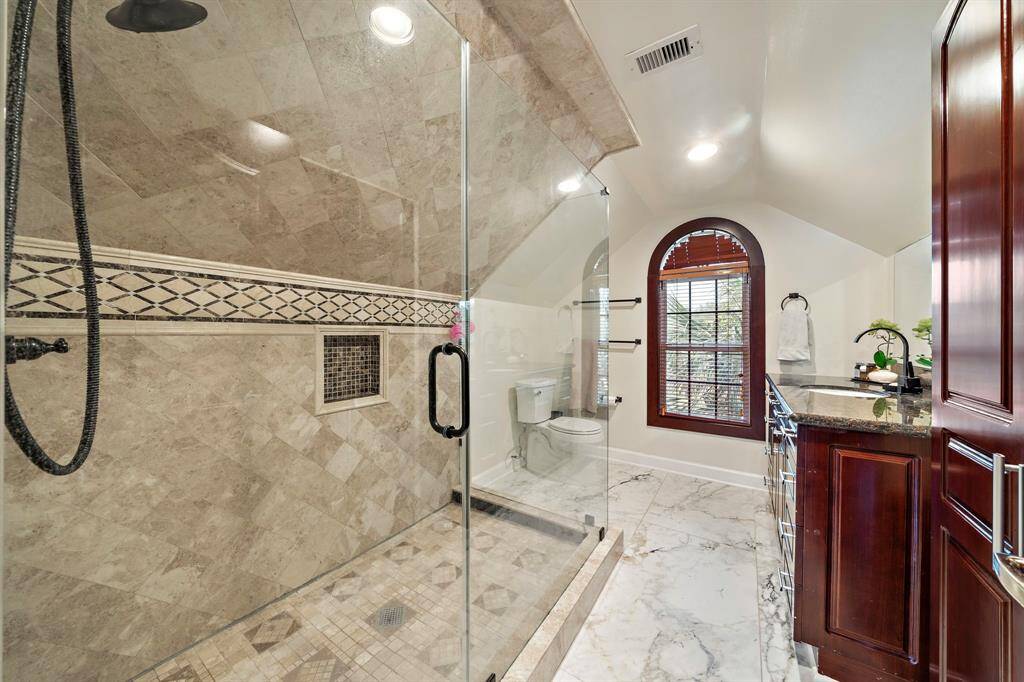 Check out the enormous shower that is attached to the upstairs primary suite. Closet space is behind the door.