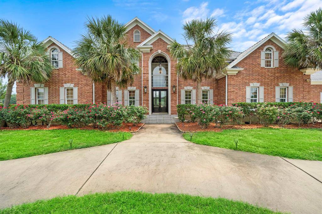 100% brick house with a tile roof. Beautiful rose bushes and palm trees line the front.