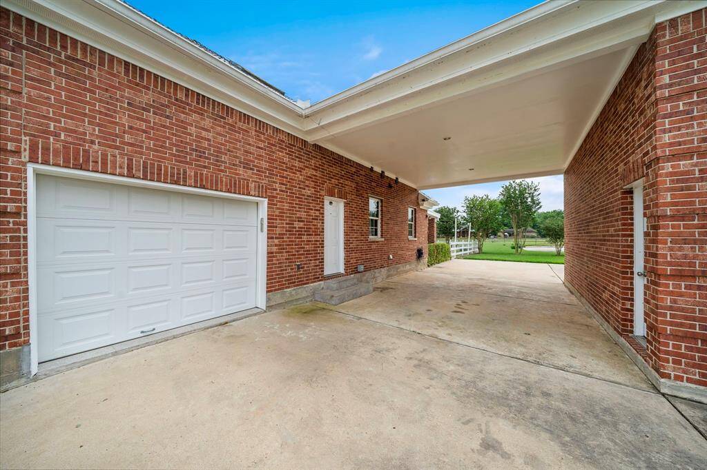 The porte-cochere with a door leading into the utility room. One garage space here and 2 more on the back side of the garage.