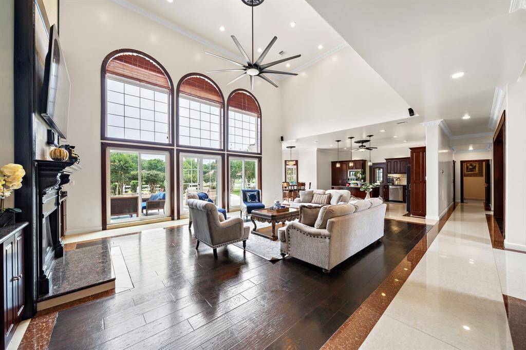 Huge two story living room with 3 sets of doors to the back yard pool area. The stacked windows offer lots of natural light. Wood floors added in 2022.
