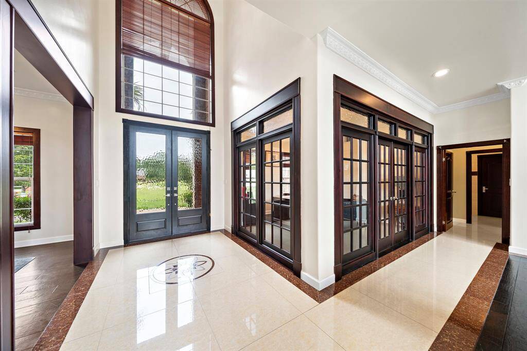 The double glass front doors lead to an inlay design on the marble floors with the enclosed study on one side and dining on the other.