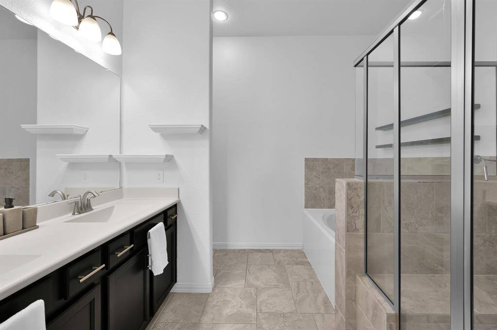 Primary bathroom with double sinks, soaking tub, and oversized shower.