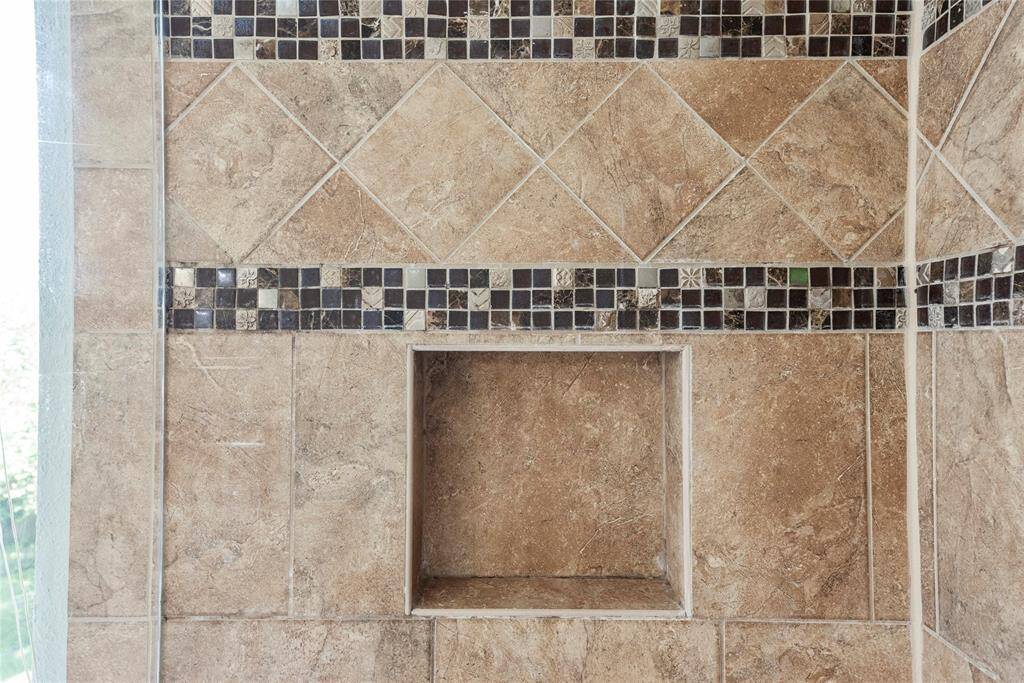 Matching tile work in the shower provides consistency in design.