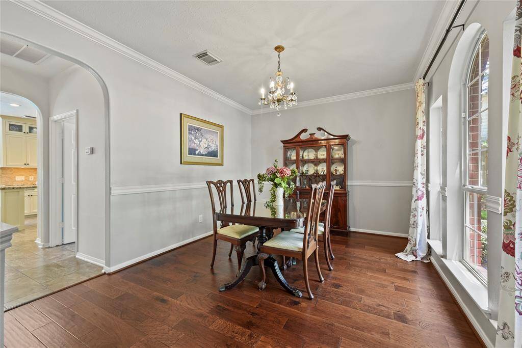 High-ceilings and hardwood floors create a formal feeling, yet the windows soften the appearance for a formal dining area.