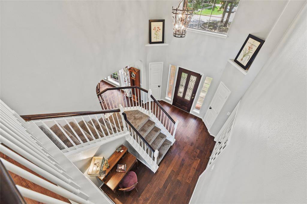 Gracefully and gently curving, the traditional wooden staircase features bright white spindles, an oak railing, and fully carpeted stairs. Visually, it appears elegant, yet inviting.