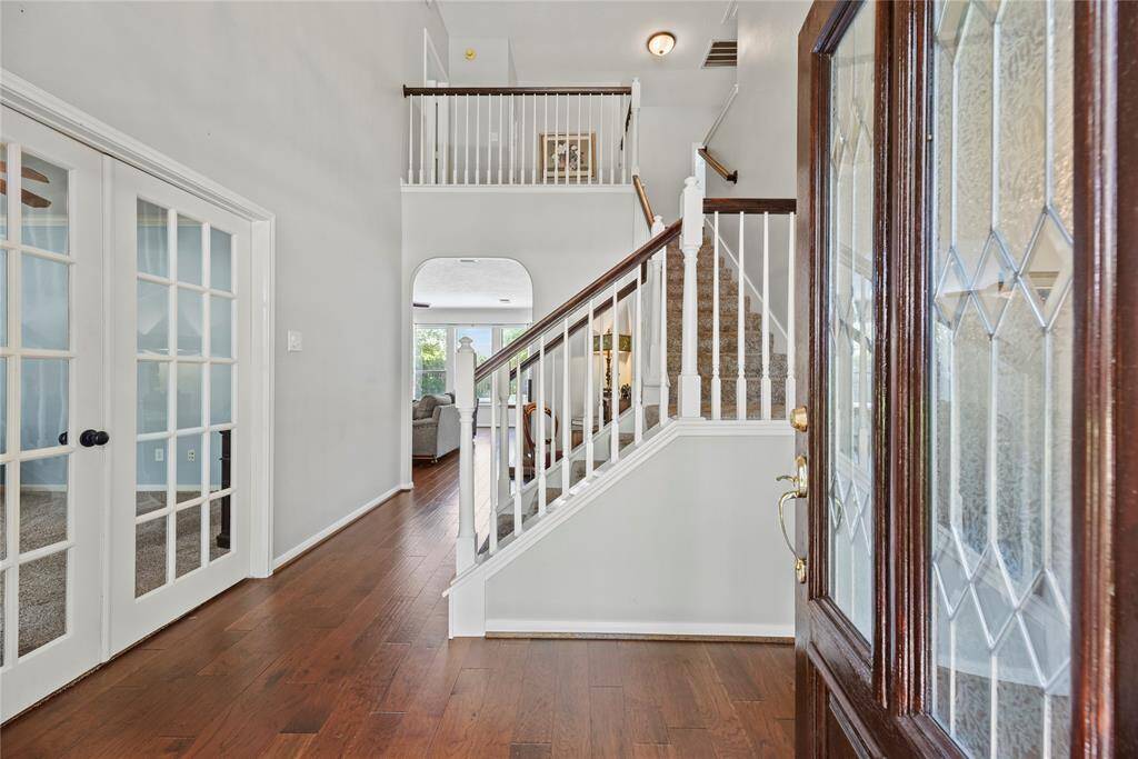 Grand and spectacular, the two-story foyer makes an impression on all your guests! Richly toned hardwood floors gleam in the presence of luminous natural light, while the above light fixture adds a touch of luxury.
