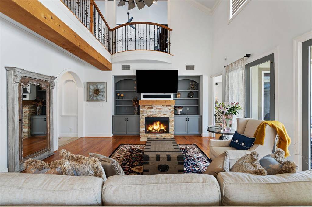 The family room boasts soaring double-height ceilings, a cozy gas fireplace, and direct access to the covered patio—perfect for effortless indoor-outdoor entertaining.