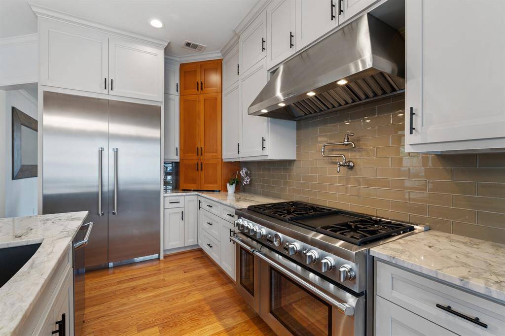 Cook in style with a top-of-the-line Thermador 6-burner gas range, complete with griddle and dual ovens.