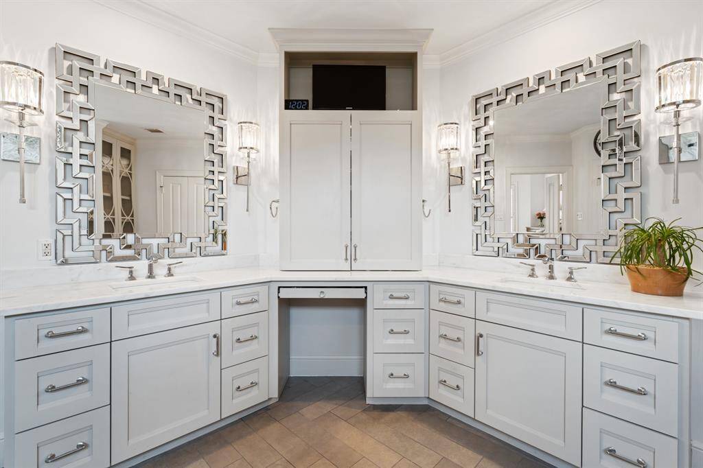 The stunning primary bath features marble counters and custom cabinetry.