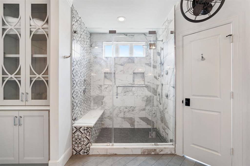 The primary bath shower features rainfall and jetted showerheads.