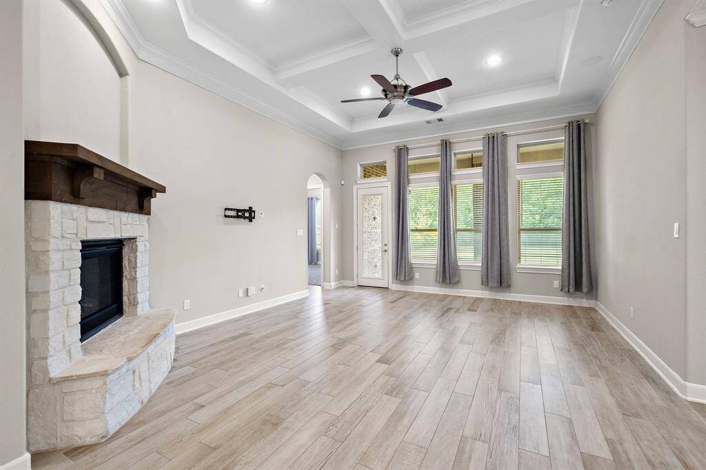 The living room features a wall of tall windows allowing for plenty of natural light to come in.