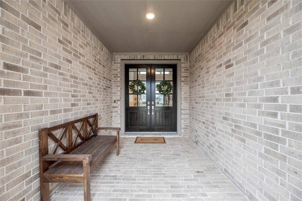 The charming brick-front porch provides the perfect spot to relax and unwind, offering a peaceful place to sit and take in the sights and sounds of the neighborhood.