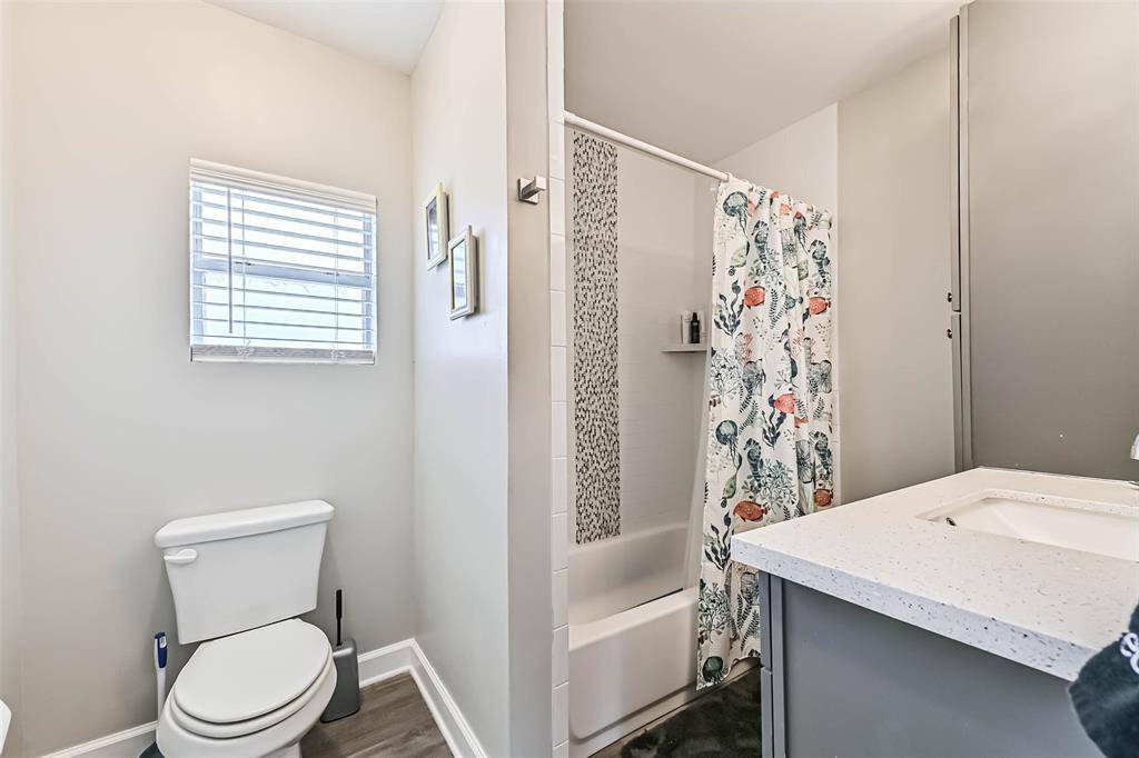 Main level restroom with tub/shower combo, vanity, and linen storage