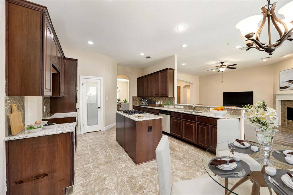 This kitchen is by far any chef’s dream! This spacious kitchen features large windows, high ceilings, dark stained wood cabinets, granite countertops, SS appliances, modern tile backsplash, recessed lighting with additional custom pendant lighting, extended counter space, granite kitchen island with double sink and space for breakfast bar and a walk-in pantry all overlooking your huge family room.