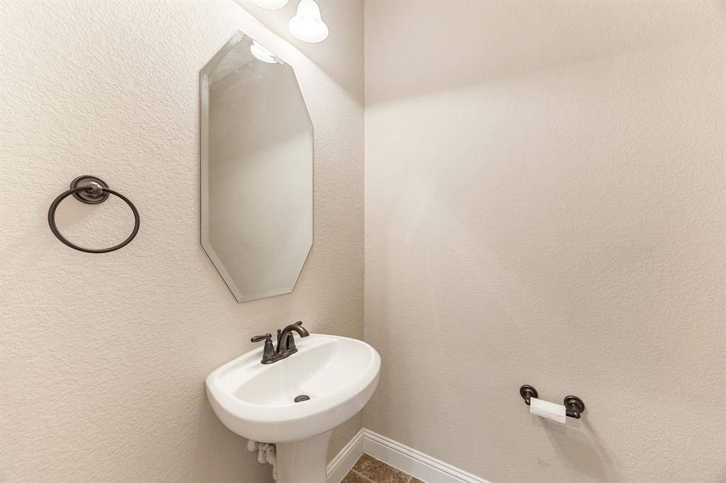 Elegant half bath featuring a timeless pedestal sink and fresh, polished finishes.