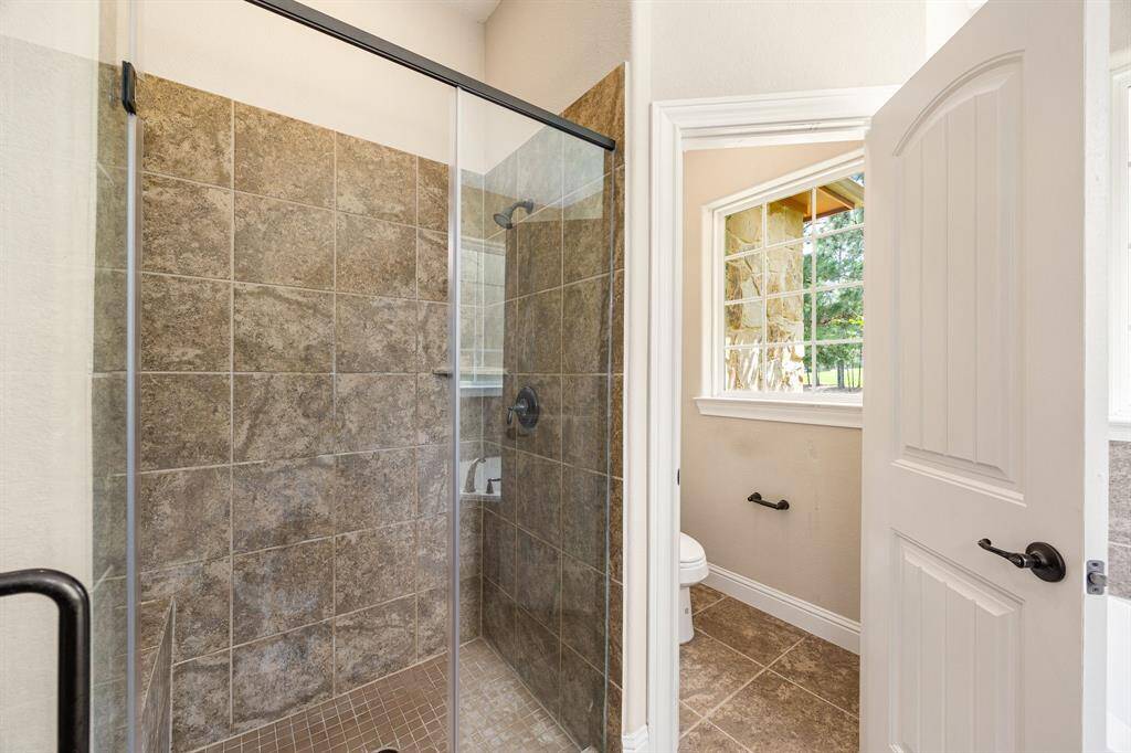 This additional view of the primary bath showcases a walk-in shower with tile surround and a separate garden tub perfect for soaking after a long day.