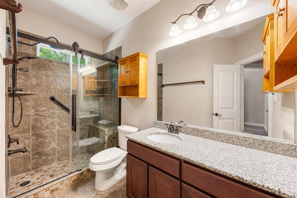 Secondary bathroom features light countertops and cabinets, custom paint, shower/tub combo with tile surround, large mirror, tile floors, sleek fixtures and modern finishes, plenty of space to accommodate any visiting family or guests.