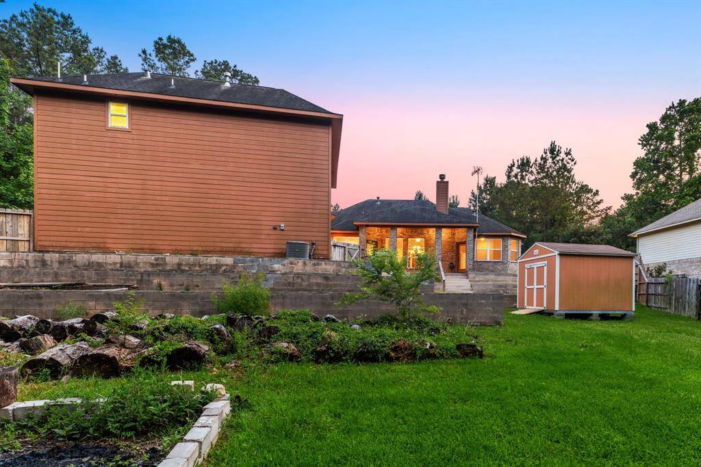 The glowing covered patio creates a warm welcome, while the tiered yard offers endless possibilities for gardening or outdoor fun.