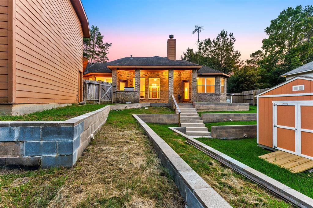 This backyard features terraced garden beds and a storage shed to create a functional outdoor space with room to grow.