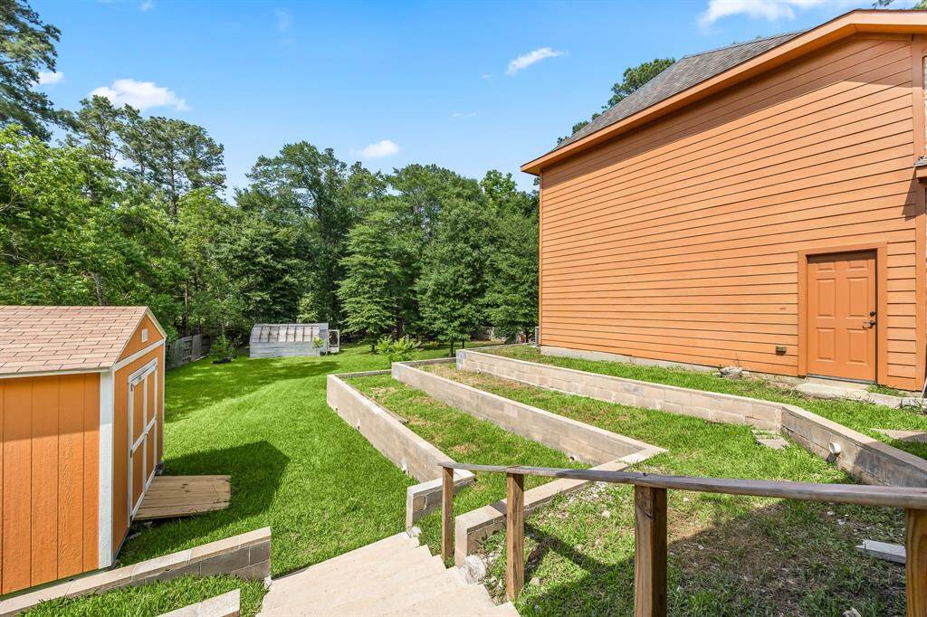 Expansive backyard surrounded by mature trees, ideal for gardening, play, or peaceful relaxation.
