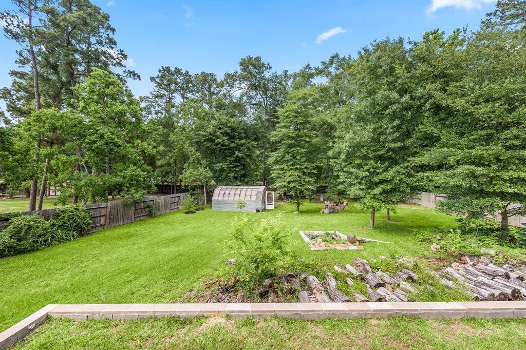 Aerial view showcases the large, private lot with tiered landscaping and wooded surroundings.