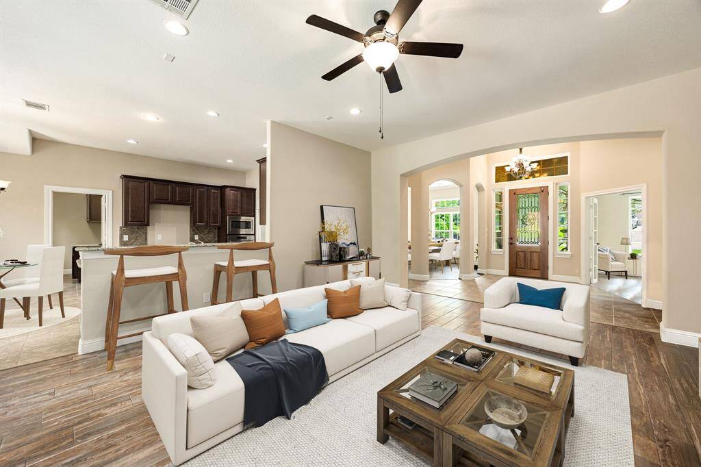 This light and bright spacious living room is the perfect layout for entertaining or just relaxing. Whether it's simply a night in or entertaining family and friends, this home has ample open space for everyone to enjoy! Featuring dark stained ceiling fan, wood style flooring, large windows, high ceilings, recessed lighting with wonderful access to your gorgeous kitchen. *Virtually Staged