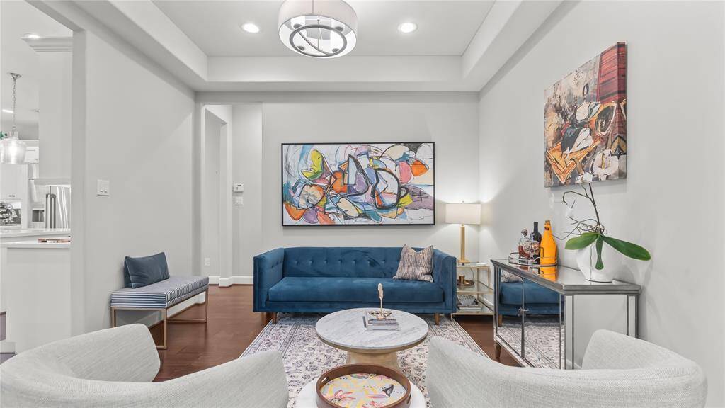 Adjacent from the kitchen is a lovely formal living room with a tiered ceiling and gallery walls. The room could also be used as a formal dining room.