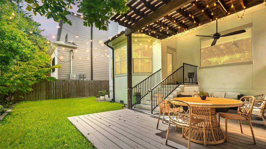 The tranquil covered trex composite deck overlooks the lush green yard.