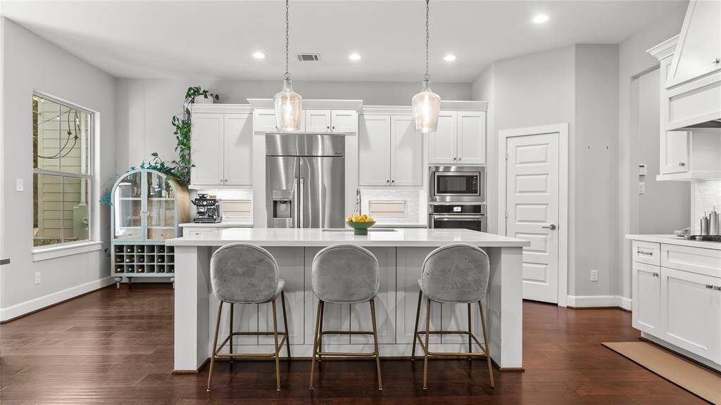 Picturesque kitchen is quite spacious with a plethora of counter space, storage and houses stainless steel appliances. Breakfast bar provides additional seating to entertain the lucky chef.