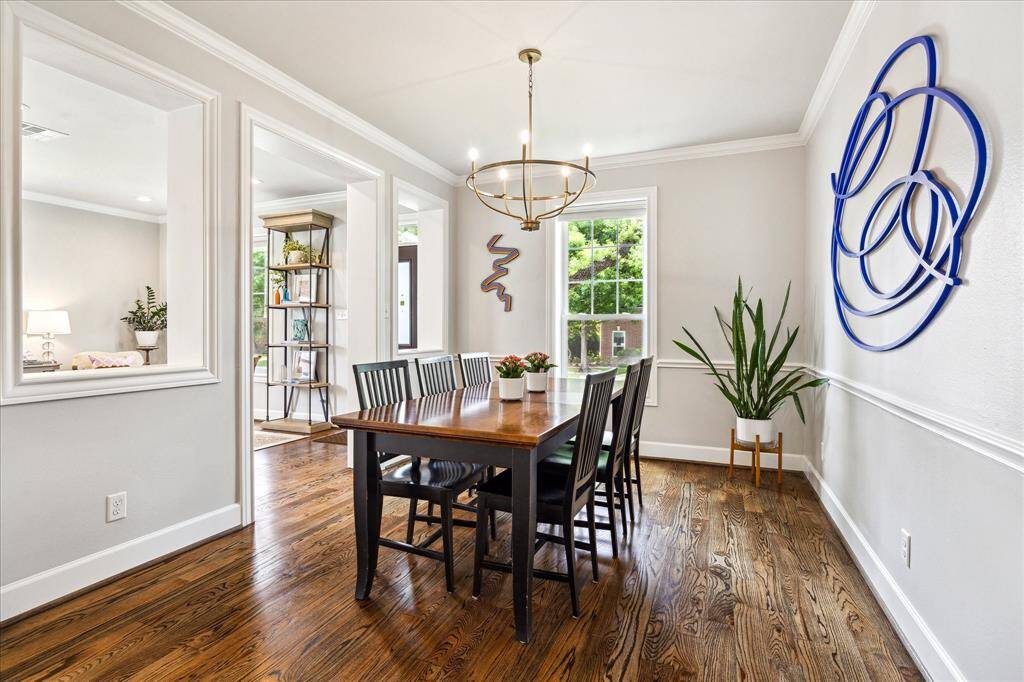 An additional view of the dining room reveals elegant sightlines into the adjacent living spaces, enhanced by architectural wall cutouts, warm natural light, and crisp millwork that frames the space with timeless sophistication.