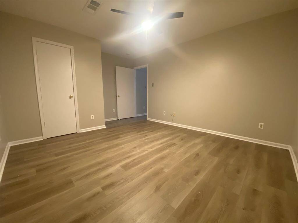 From the other side of the primary bedroom you will see the closet door. The closet is a standard-size closet with rods for hanging.